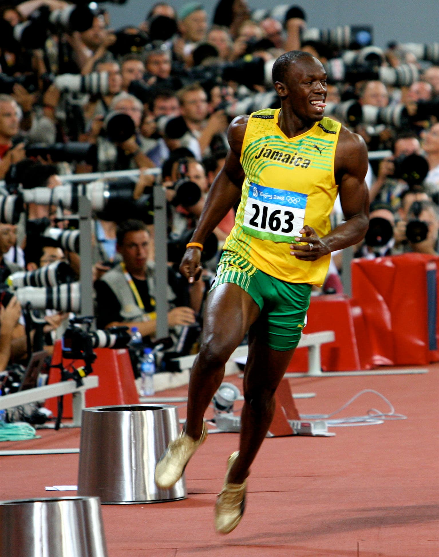 Usain Bolt célébrant, bras écartés, juste après une course.
