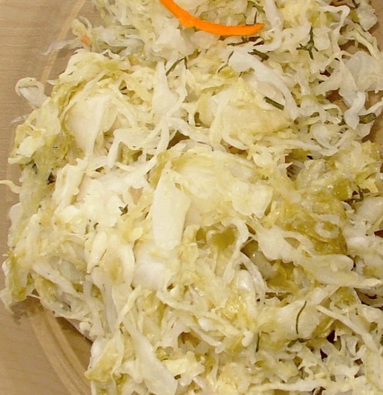 A bowl of pale, finely shredded fermented cabbage.