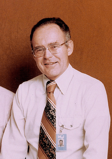 Photo en noir et blanc de Gordon Moore, un homme à lunettes en costume, prise à la fin des années 1970.