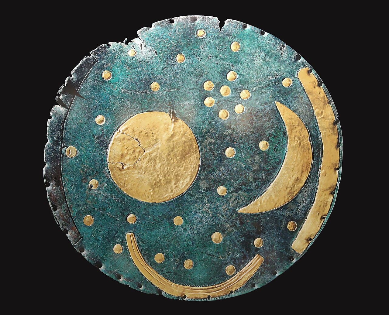 A dark bronze disc inlaid with gold symbols representing the sun, a crescent moon, and stars, from Bronze Age Europe.