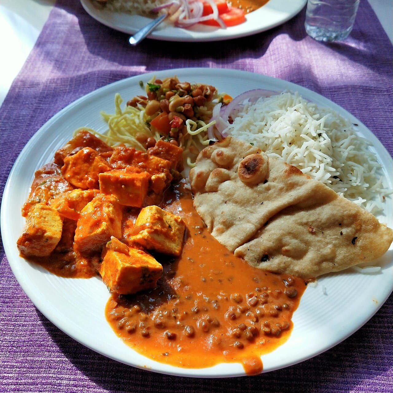 Assiette de nourriture végétarienne avec des légumes, des légumineuses et du riz.