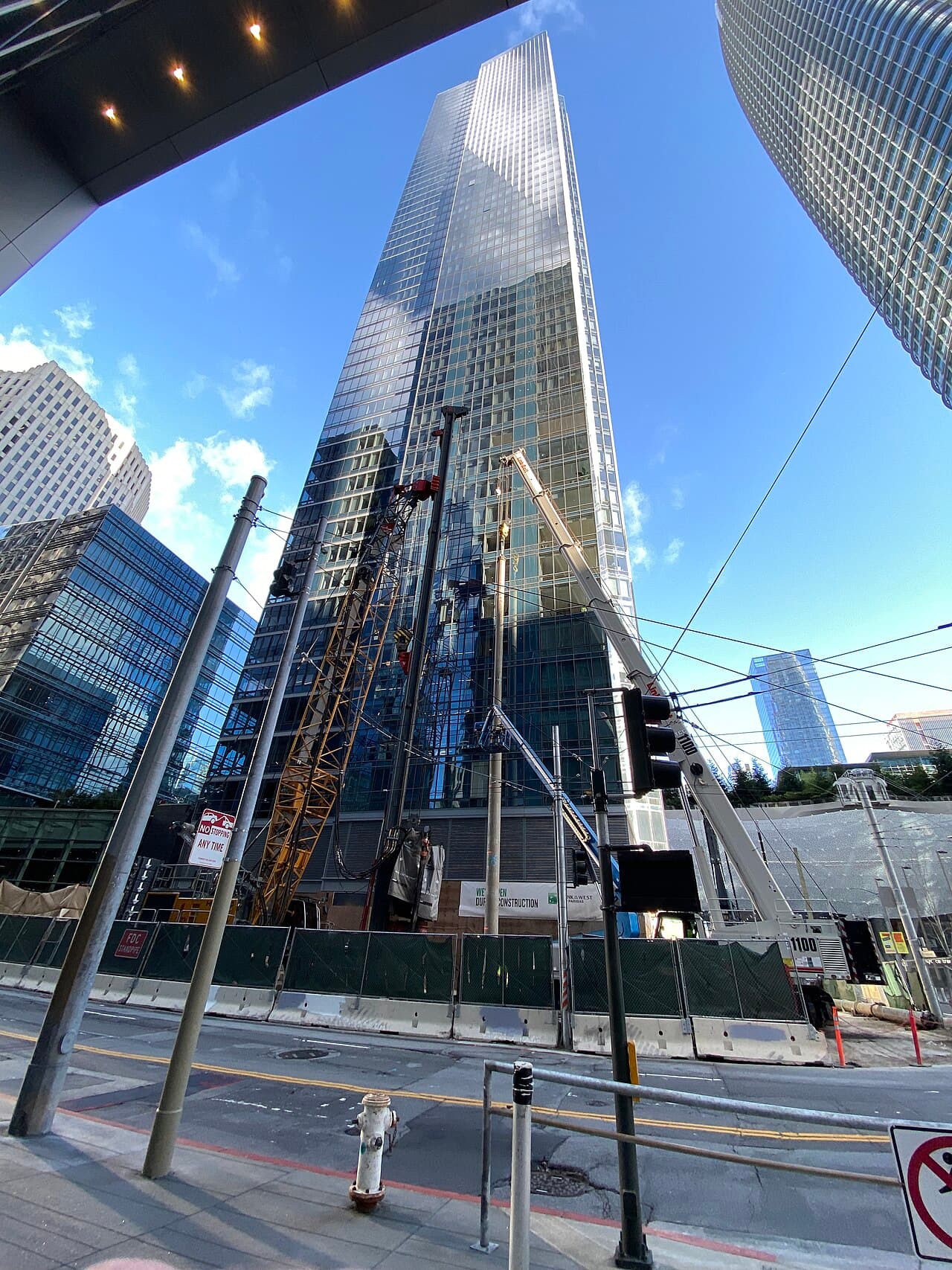Des ouvriers et des équipements installant une nouvelle section de pieu de fondation près de la base de la Millennium Tower à San Francisco.