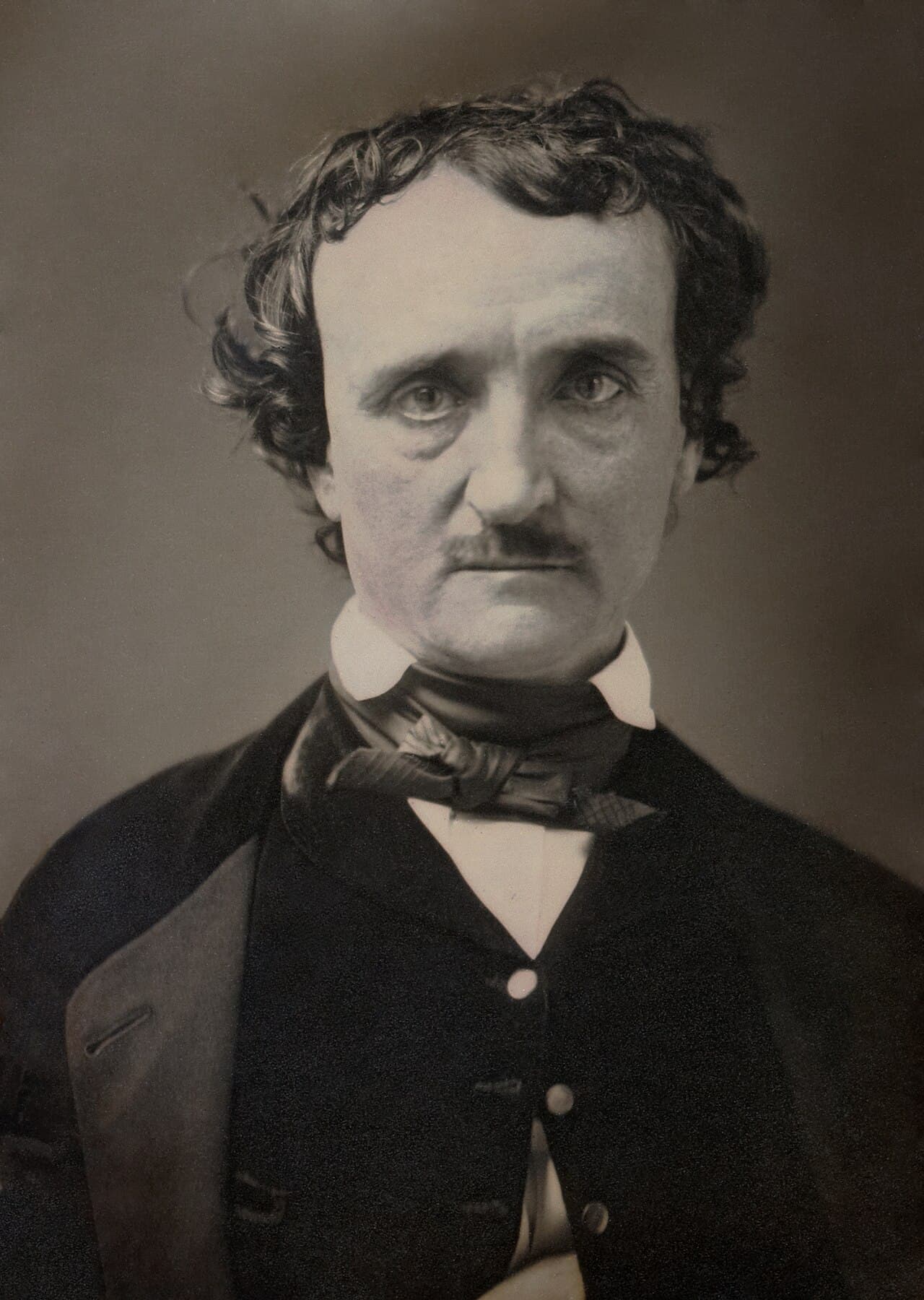 A black-and-white photographic portrait of Edgar Allan Poe, seated, with a serious expression, circa 1849.