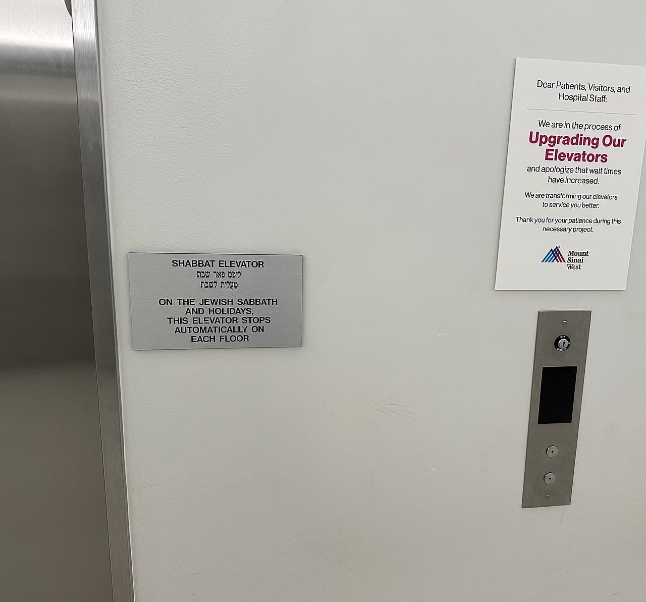 Une plaque métallique à côté des portes d'un ascenseur indique en anglais et en hébreu : « Ascenseur de chabbat : pendant le sabbat juif et les fêtes, cet ascenseur s'arrête automatiquement à chaque étage ».