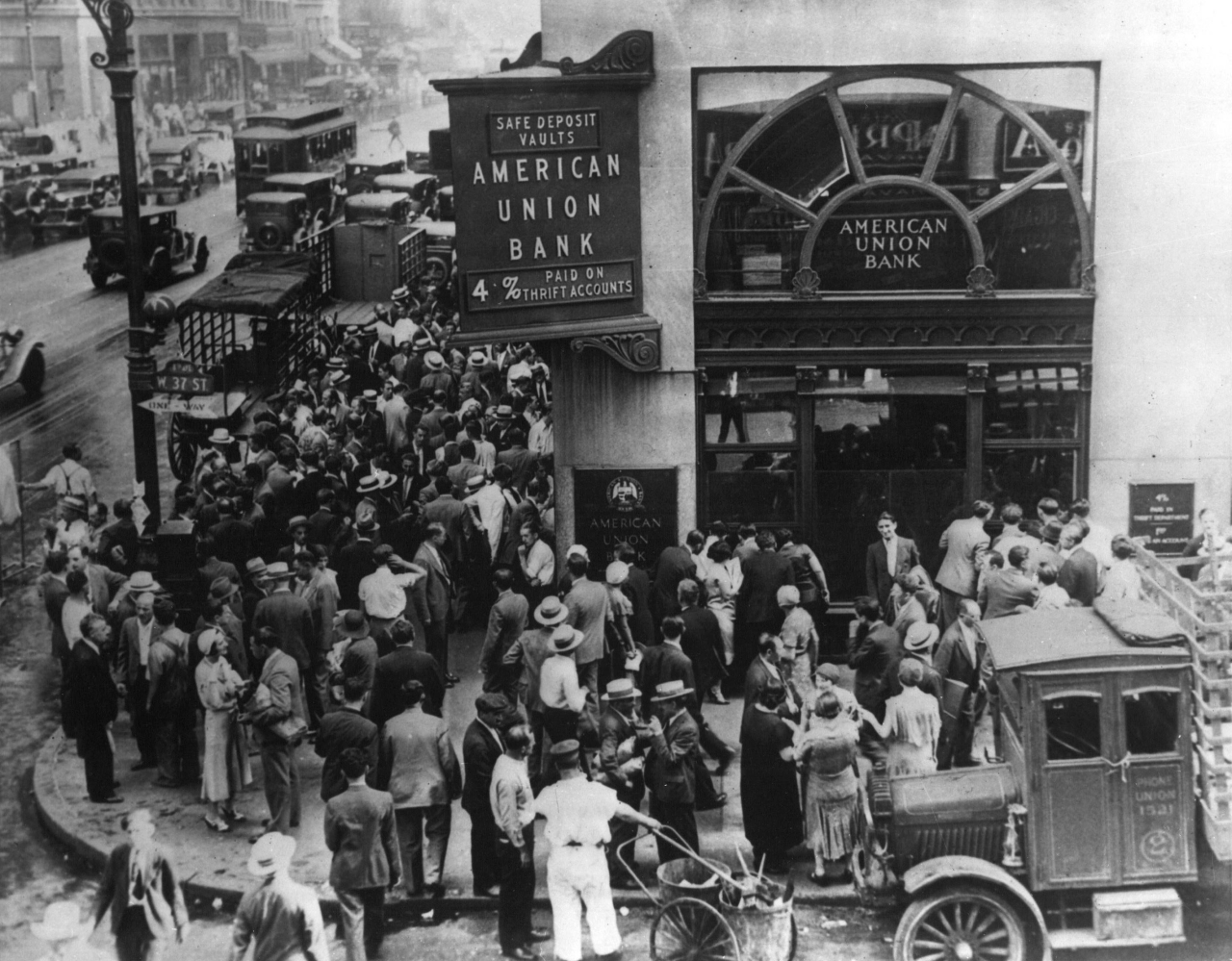 Black-and-white photo of a large crowd of people packed outside the doors of a bank in New York.