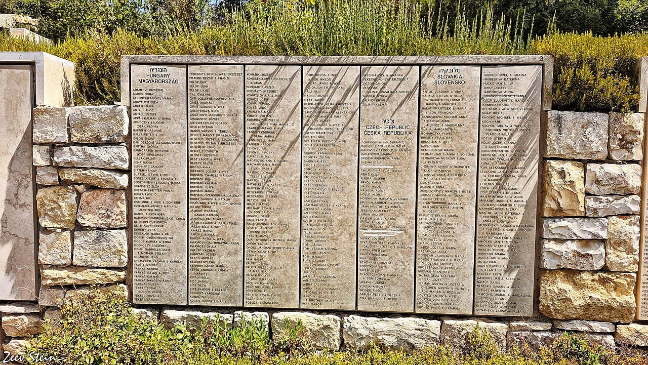 Une allée boisée bordée de murs de pierre gravés de noms, dans le Jardin des Justes parmi les nations à Yad Vashem.